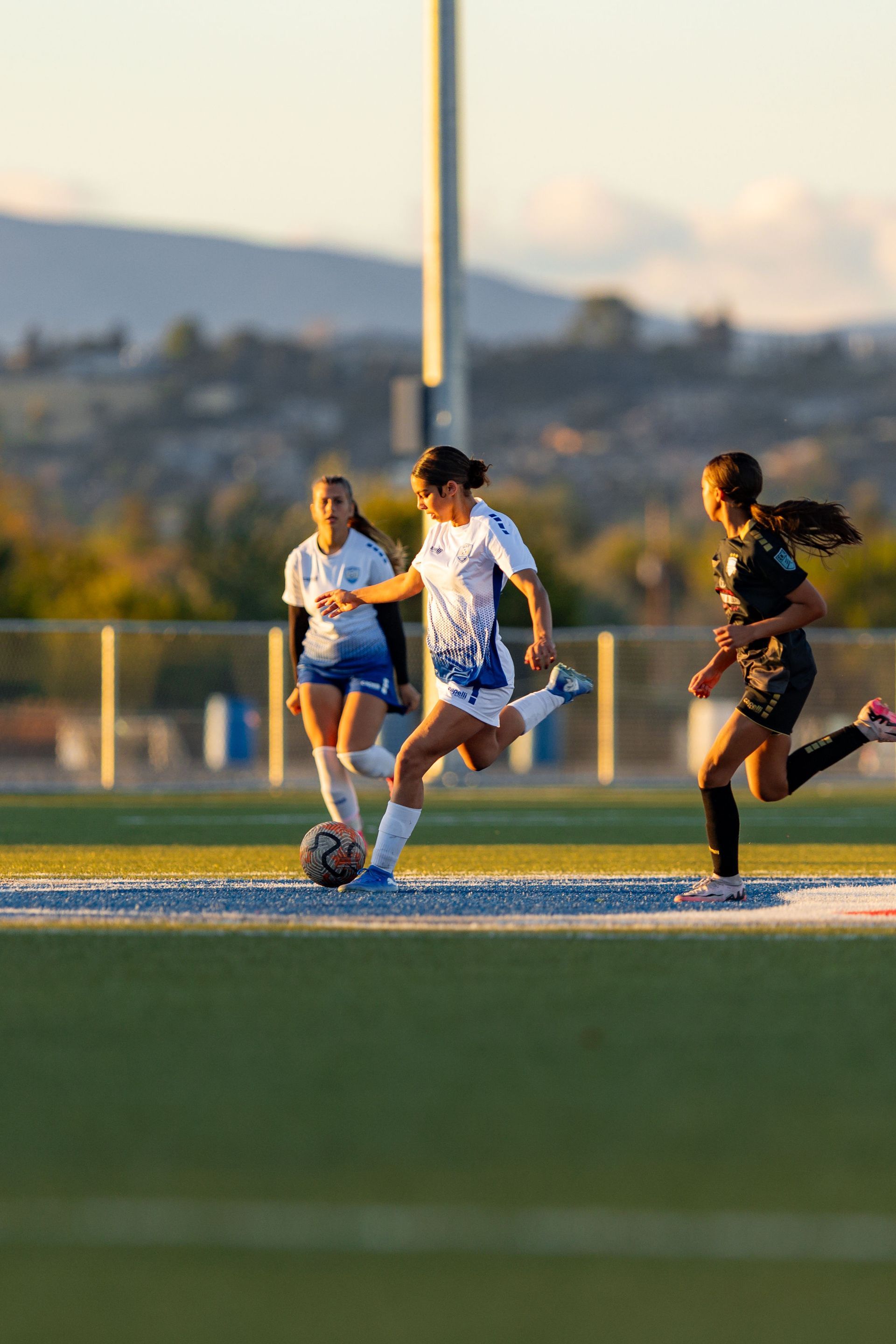 A group of women are playing soccer on a field.