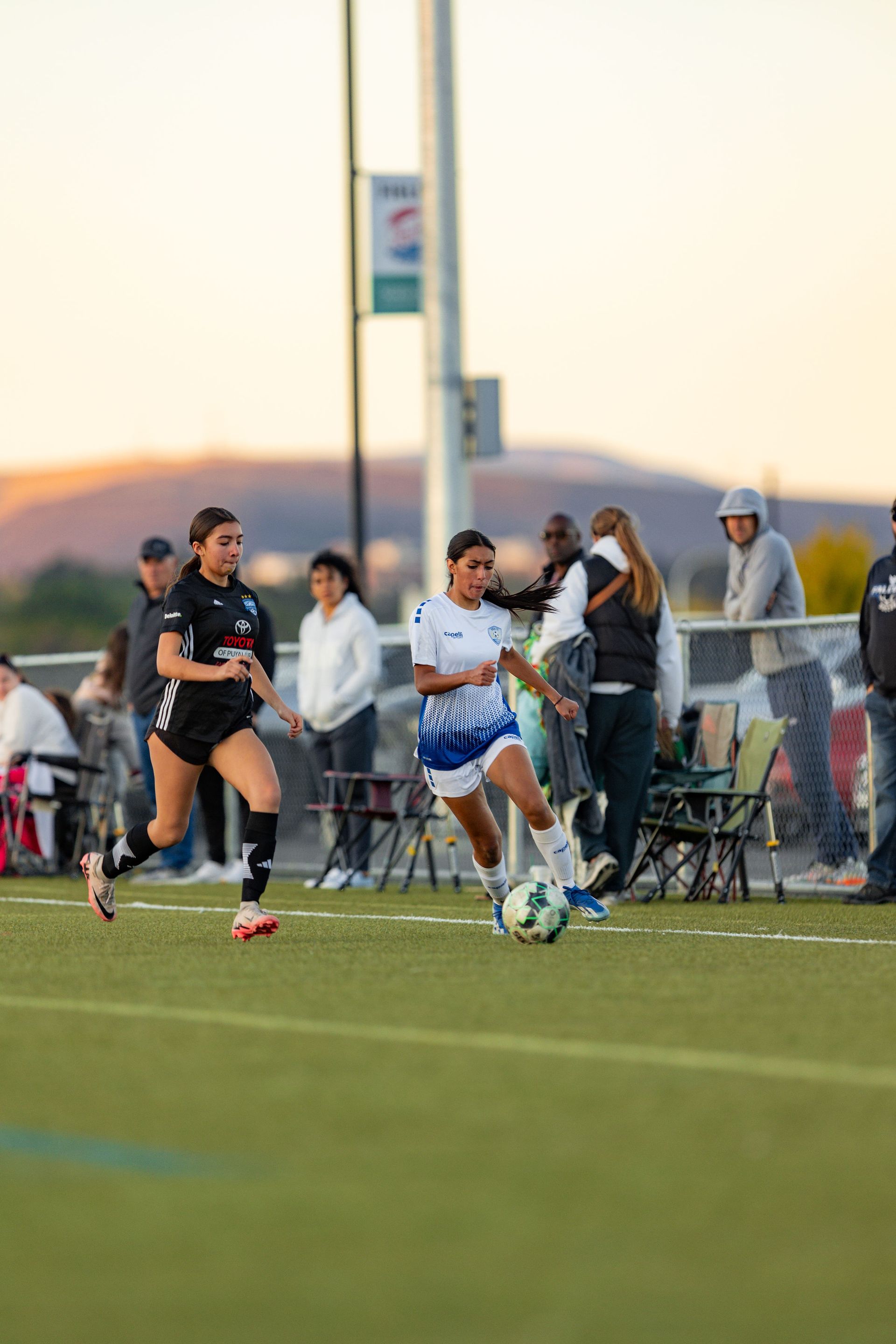 A group of women are playing soccer on a field.