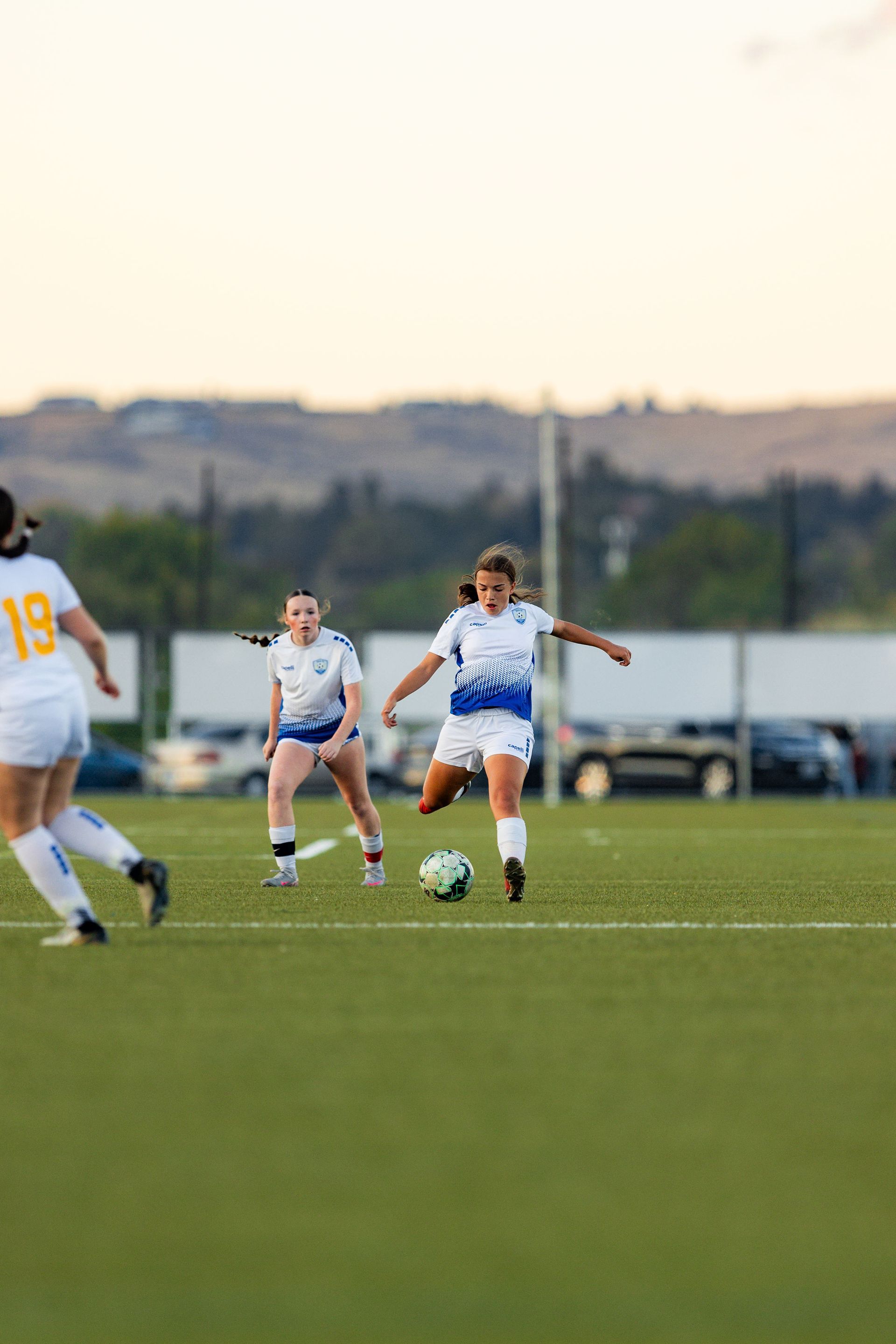 A group of women are playing soccer on a field.
