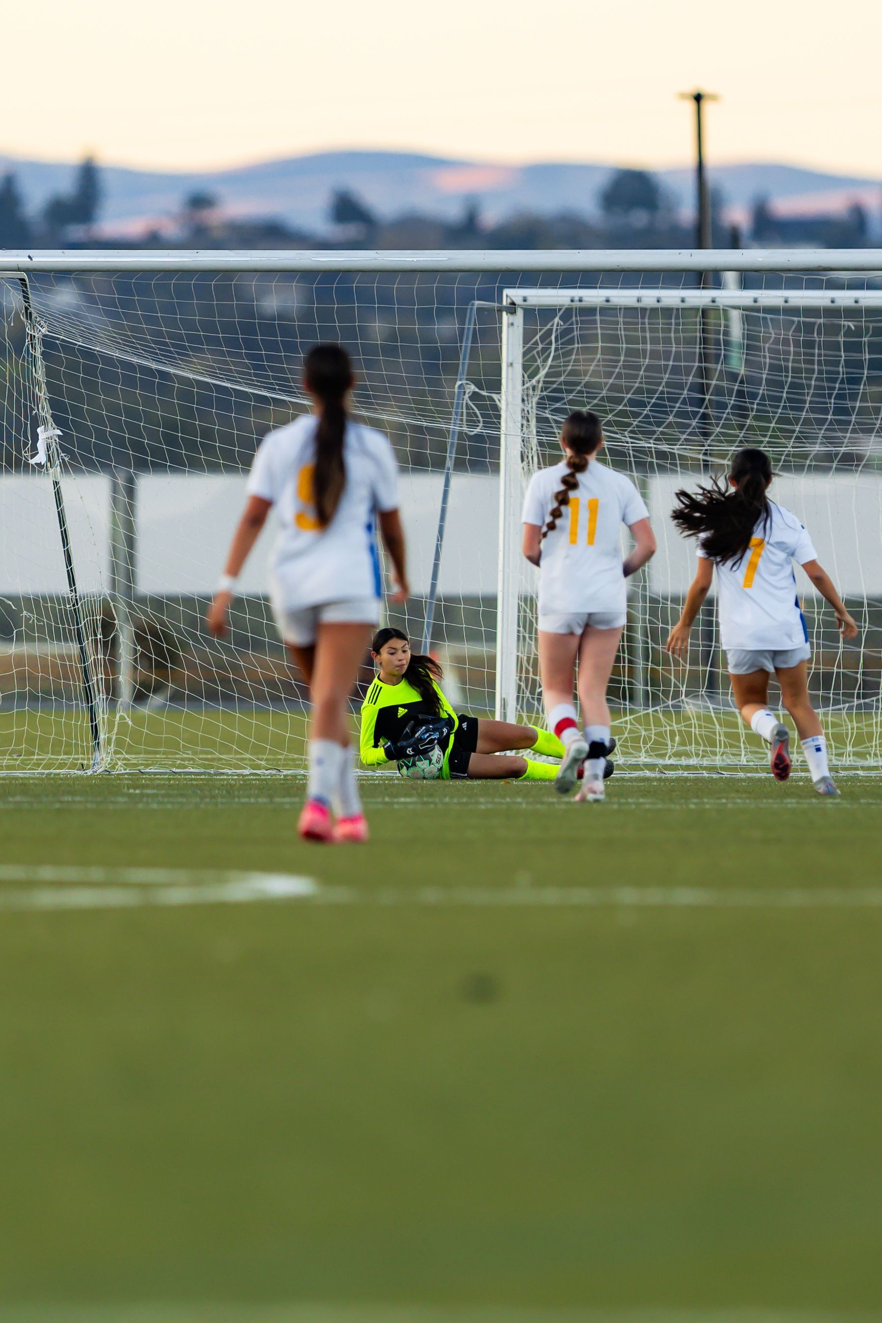 A group of women are playing soccer on a field.