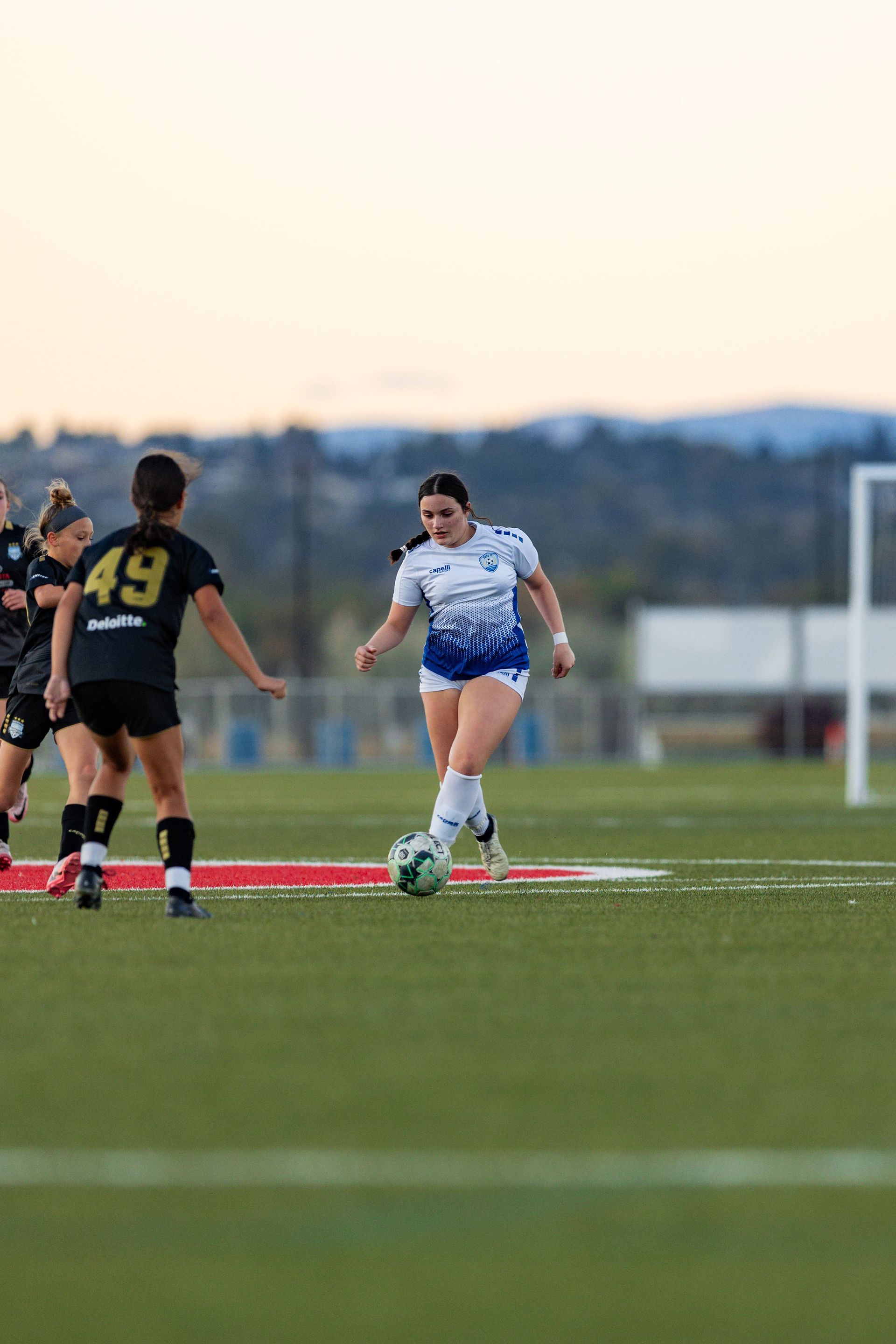 A group of women are playing soccer on a field.