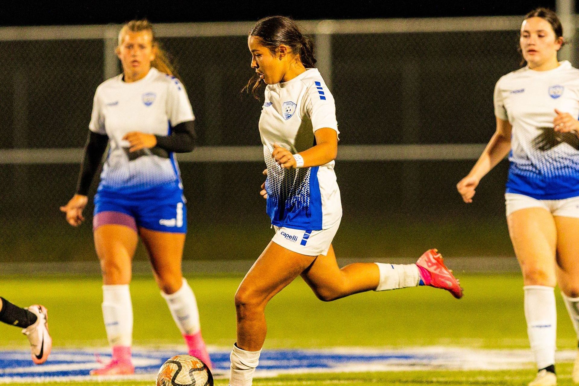 A group of women are playing soccer on a field.