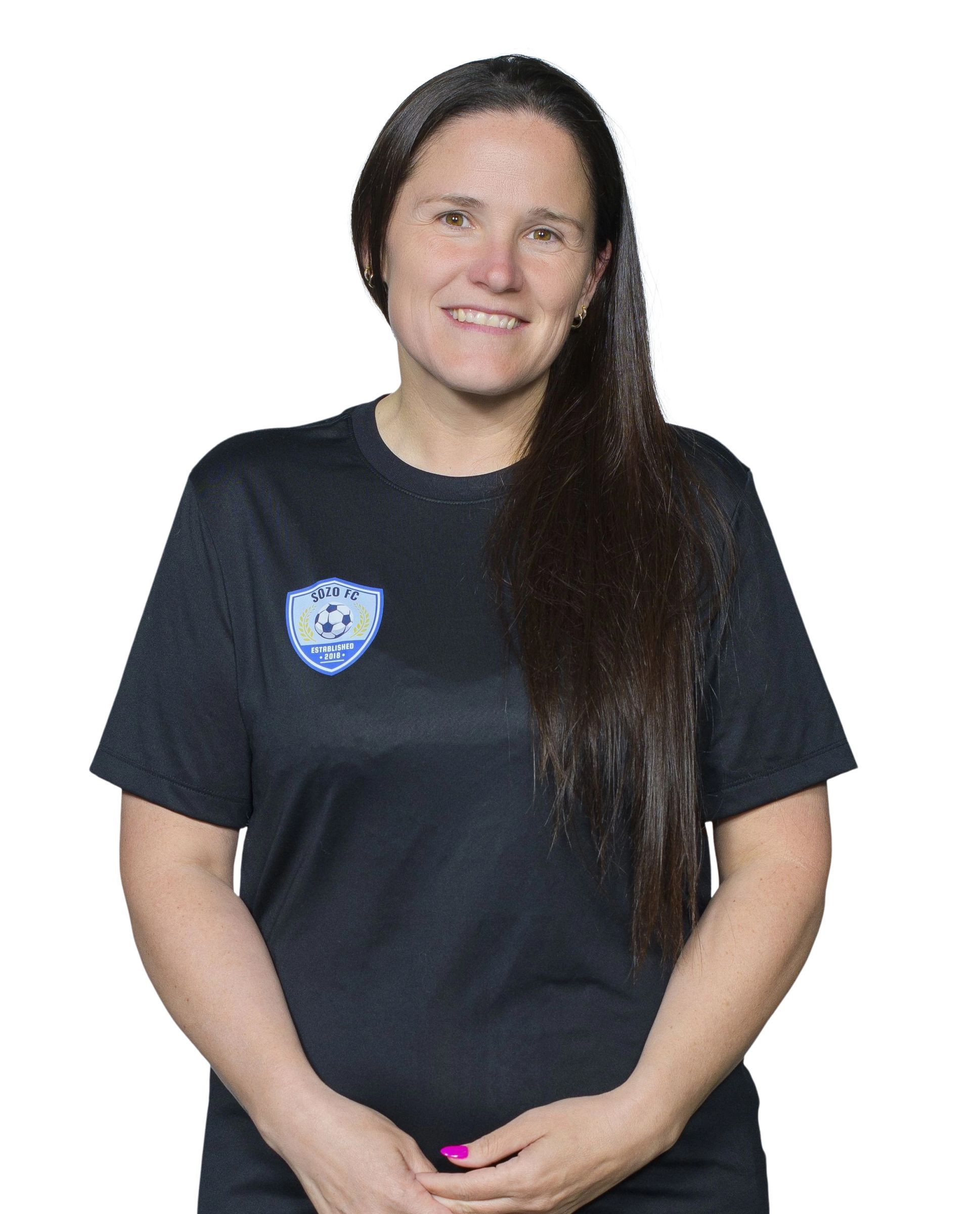 Person in a black T-shirt with a blue logo, standing and smiling against a white background.