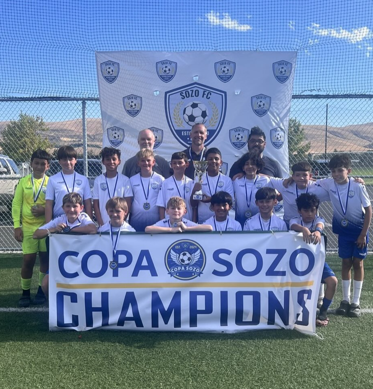 A group of young boys are posing for a picture with a sign that says copa sozo champions.