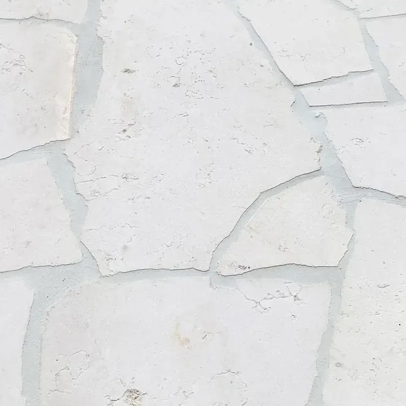 White stone wall with irregular, angular shapes and light gray grout — Premier Bricks, Blocks & Pavers In Heatherbrae, NSW