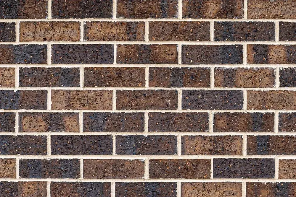Brown and black brick wall with white mortar — Premier Bricks, Blocks & Pavers In Heatherbrae, NSW