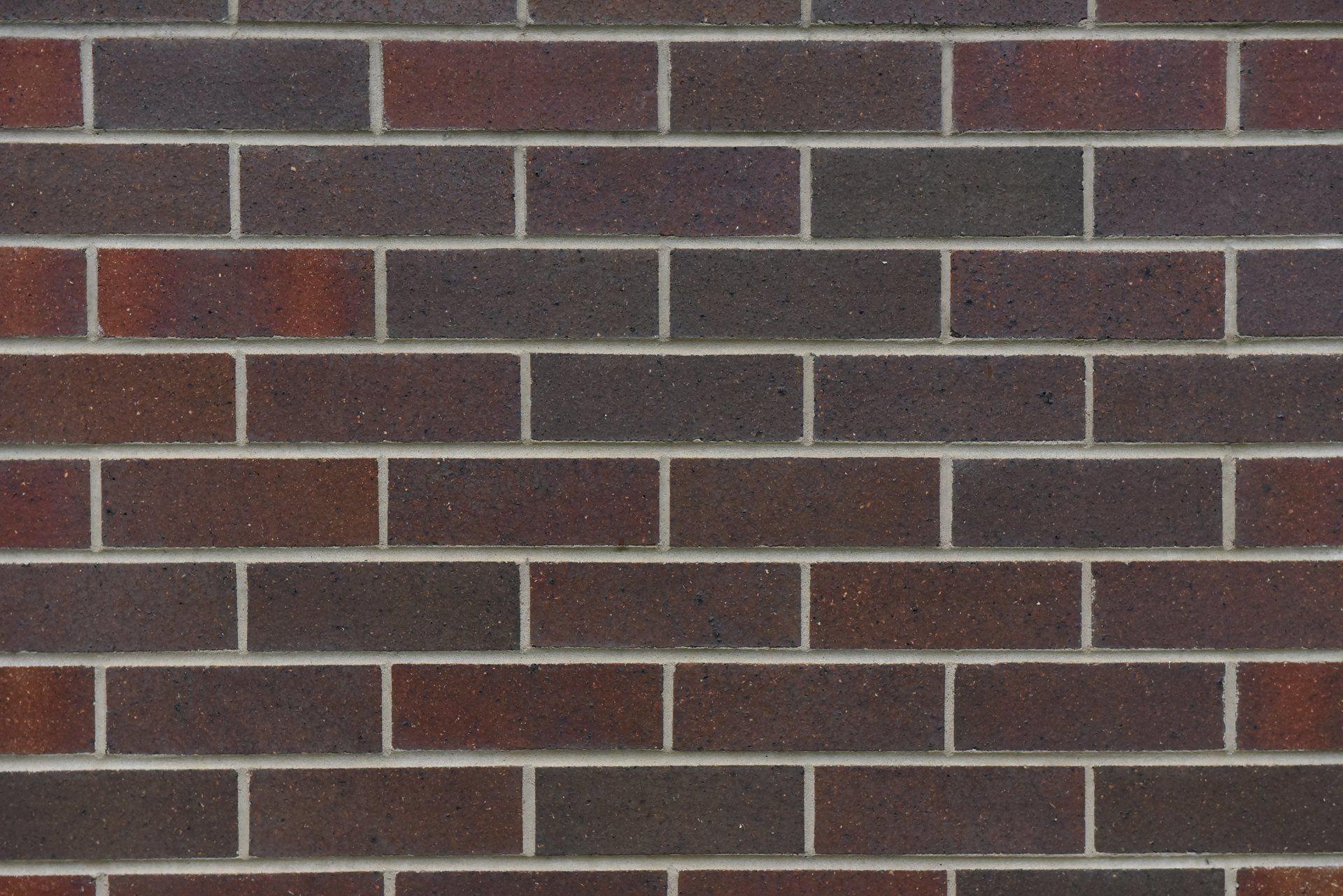 Brick wall with alternating dark brown and reddish-brown bricks — Premier Bricks, Blocks & Pavers In Heatherbrae, NSW
