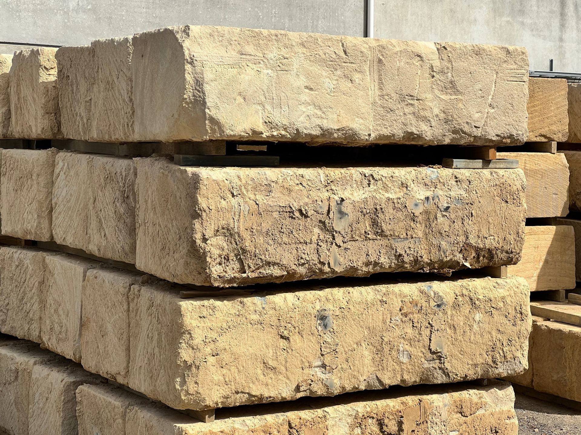 A Stack Of SANDSTONESitting On Top Of Each Other On The Ground — Premier Bricks, Blocks & Pavers In Heatherbrae, NSW