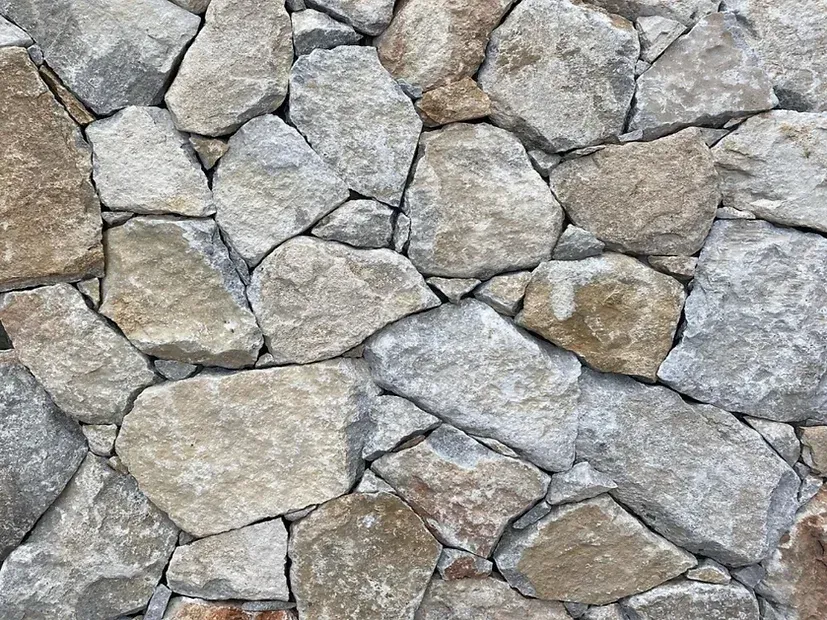 Stone wall, composed of irregular, light gray and tan rocks — Premier Bricks, Blocks & Pavers In Heatherbrae, NSW