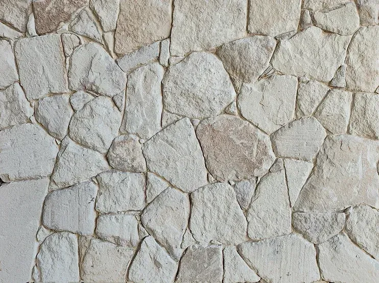 Stone wall with irregular beige and light brown stones — Premier Bricks, Blocks & Pavers In Heatherbrae, NSW