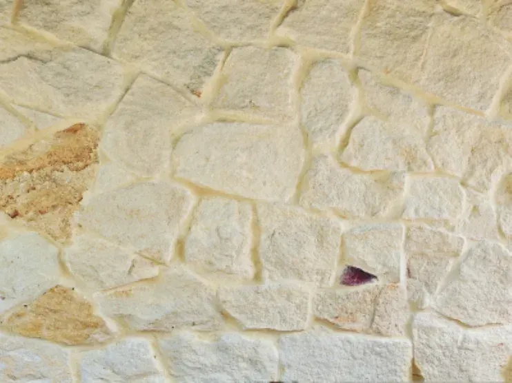 Cream-colored stone wall with irregular shapes and grout lines — Premier Bricks, Blocks & Pavers In Heatherbrae, NSW
