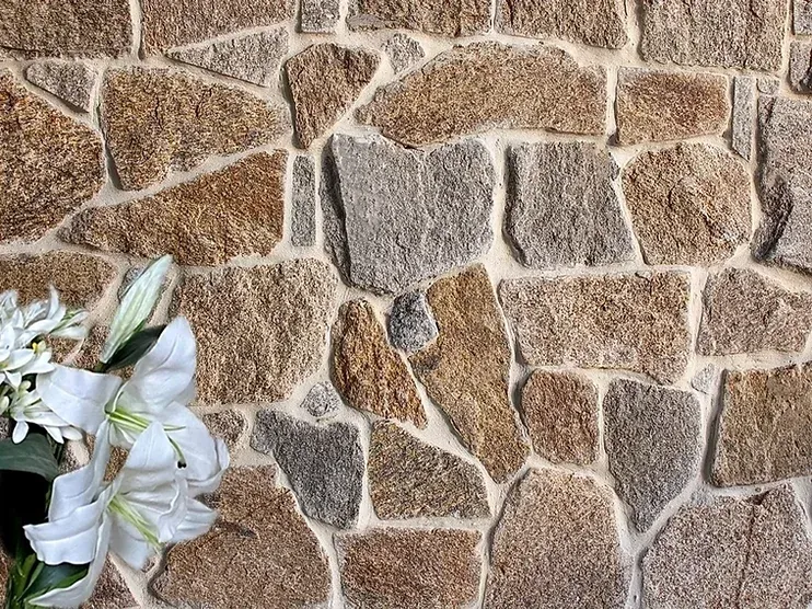 Stone wall with varying shades of brown and gray stones — Premier Bricks, Blocks & Pavers In Heatherbrae, NSW
