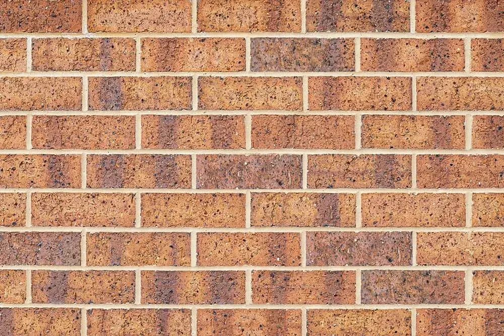 Brown and tan brick wall with light-colored mortar — Premier Bricks, Blocks & Pavers In Heatherbrae, NSW