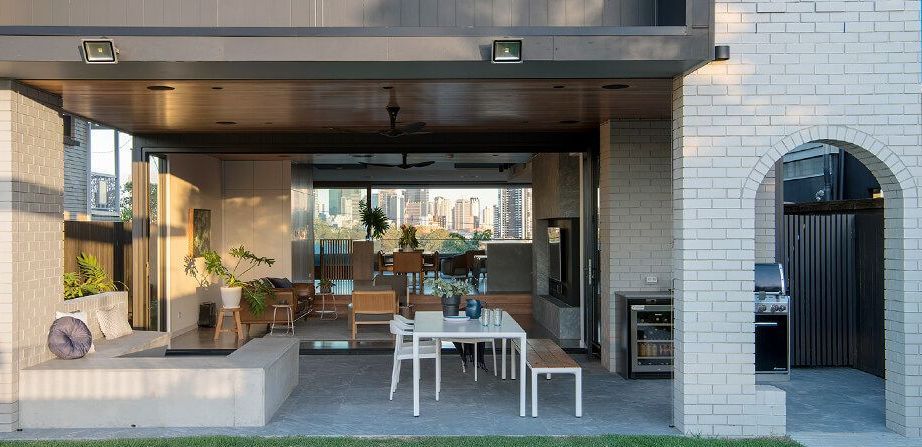 Outdoor patio with dining table, benches, and a barbecue area — Premier Bricks, Blocks & Pavers In Heatherbrae, NSW