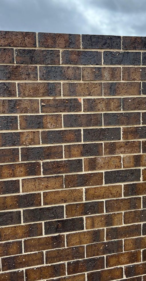 A Close Up Of A Brown Brick Wall With A Cloudy Sky In The Background — Premier Bricks, Blocks & Pavers In Port Stephens, NSW