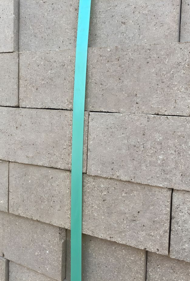 A Close Up Of A Brick Wall With A Green Strap — Premier Bricks, Blocks & Pavers In Newcastle, NSW