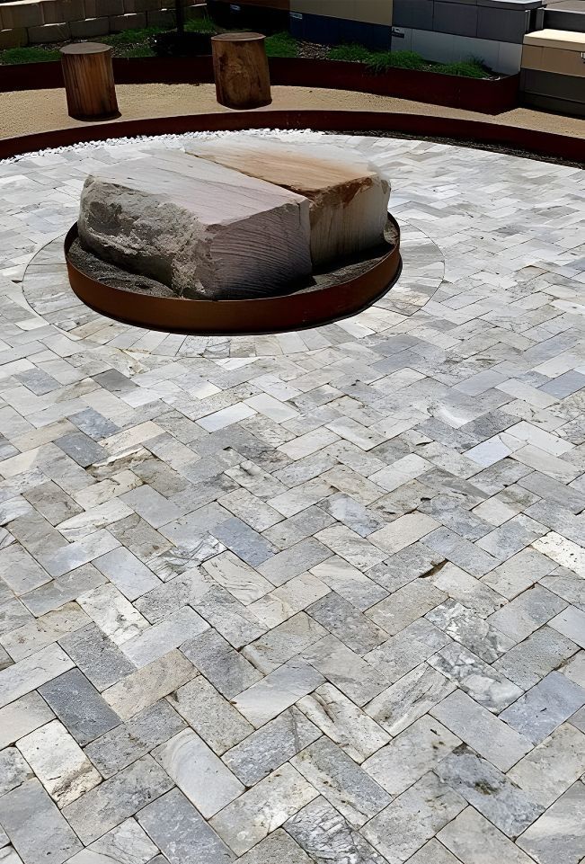 A Stone Bench Is Sitting In The Middle Of A Brick Patio — Premier Bricks, Blocks & Pavers In Singleton, NSW