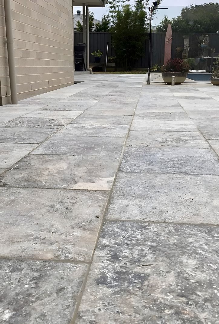 A Concrete Walkway Leading To A Building With A Fence In The Background — Premier Bricks, Blocks & Pavers In Cessnock, NSW