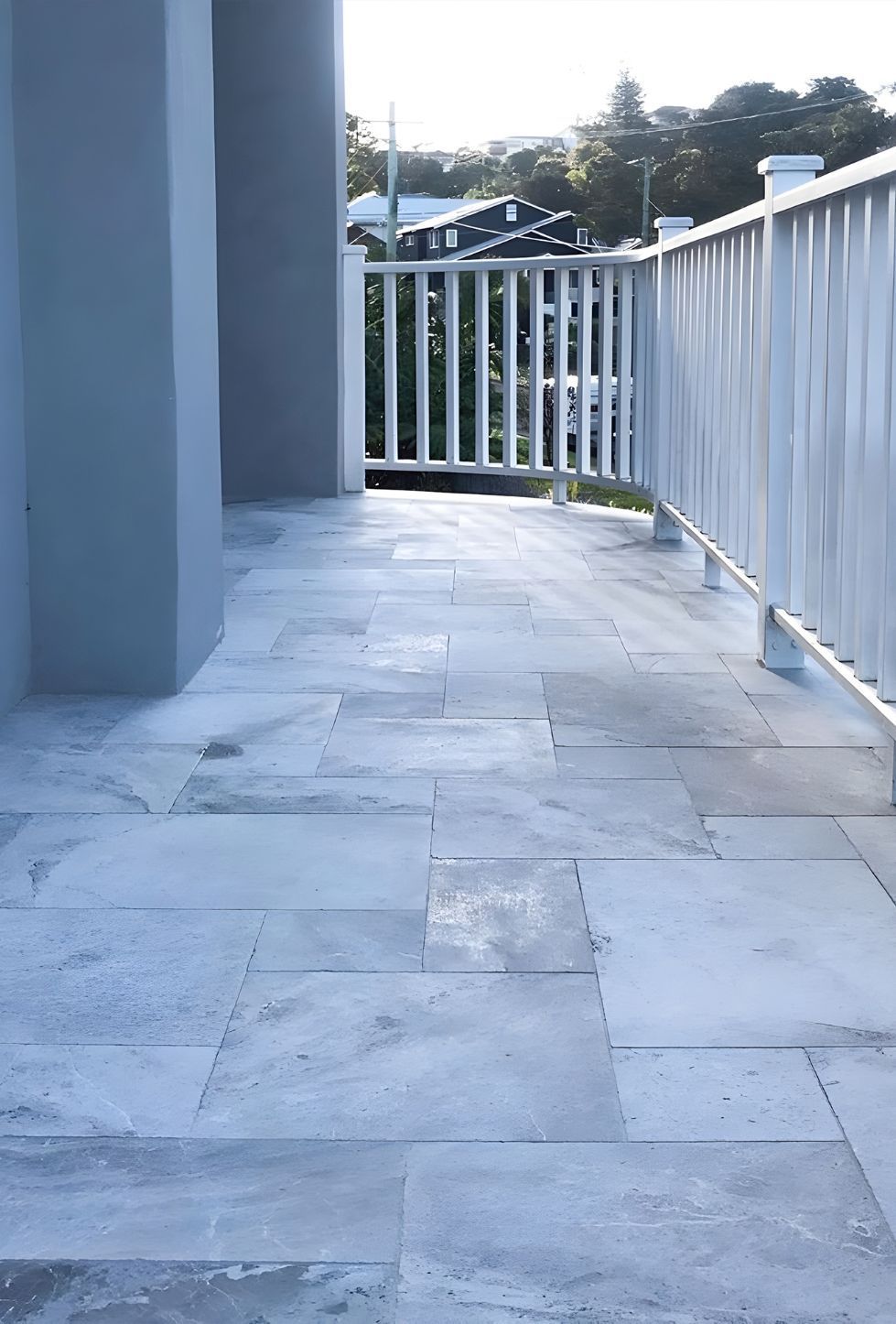 A Balcony With A White Railing And A White Tile Floor — Premier Bricks, Blocks & Pavers In Port Stephens, NSW