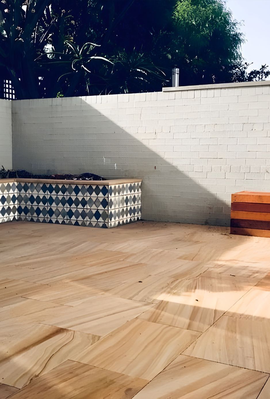 A White Brick Wall With A Wooden Bench In The Background — Premier Bricks, Blocks & Pavers In Merewether, NSW