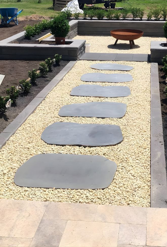 A Row Of Stepping Stones Leading To A Fire Pit In A Garden — Premier Bricks, Blocks & Pavers In Hawks Nest, NSW