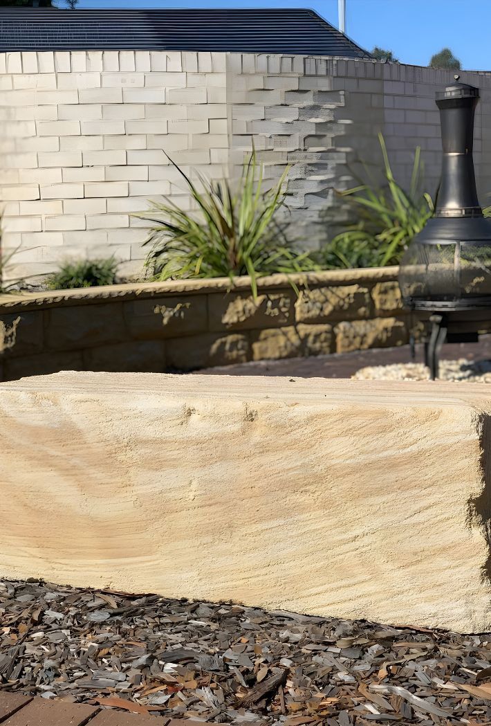 A Fire Pit Is Sitting In Front Of A Brick Wall — Premier Bricks, Blocks & Pavers In Merewether, NSW