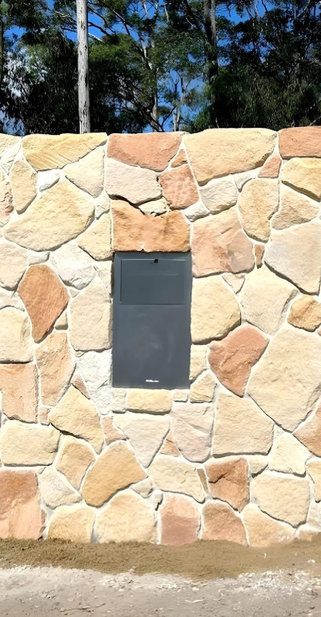 A sandstone wall with a postbox— Premier Bricks, Blocks & Pavers In Heatherbrae, NSW