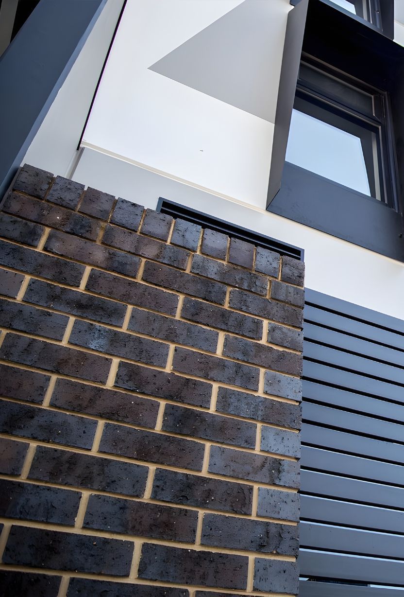 A Close Up Of A Brick Wall With A Window In The Background — Premier Bricks, Blocks & Pavers In Maitland, NSW