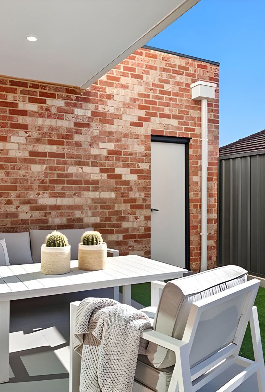 A Patio With A Table And Chairs In Front Of A Brick Wall — Premier Bricks, Blocks & Pavers In Maitland, NSW