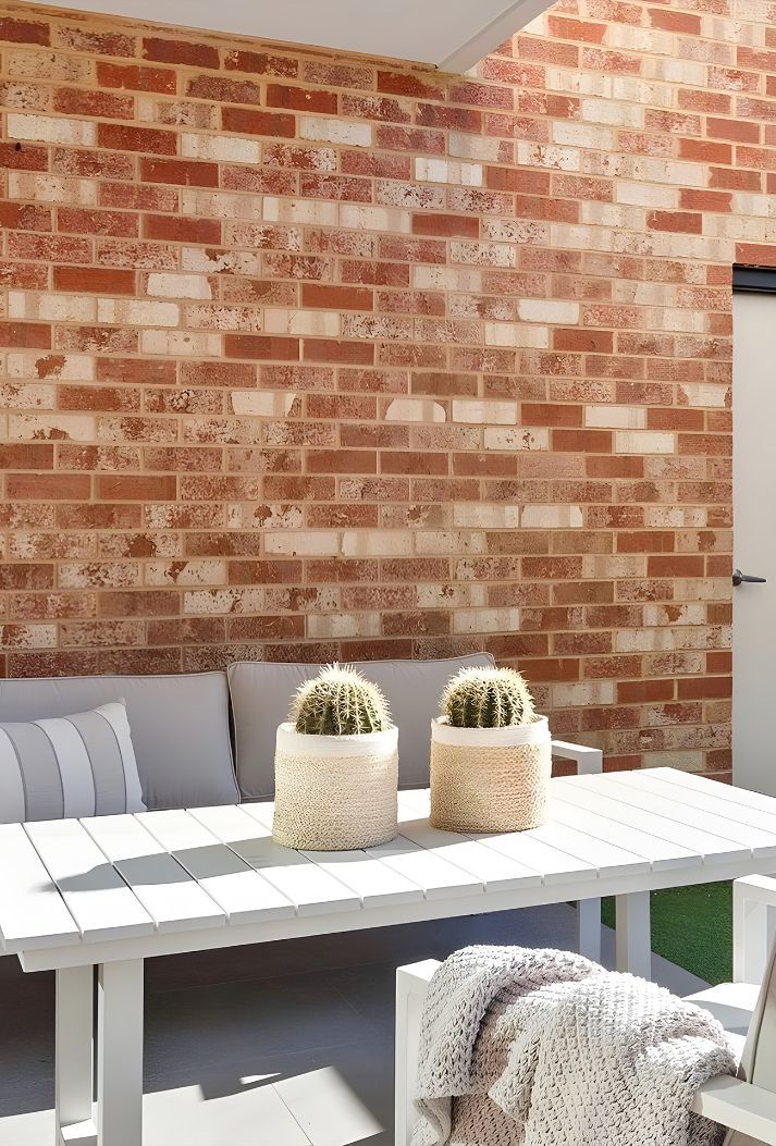 A Patio With A White Table And A Brick Wall — Premier Bricks, Blocks & Pavers In Singleton, NSW
