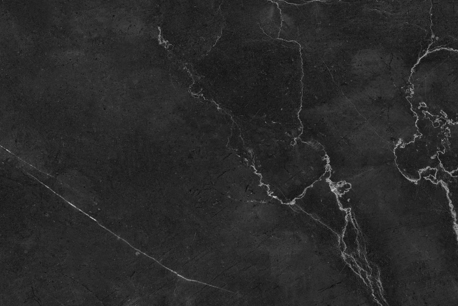 A close up of a black marble texture with white veins.