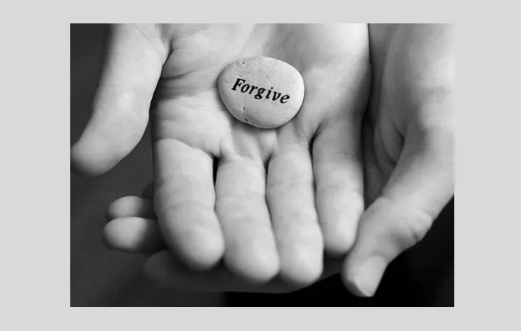 Hand Holding a Stone with a Forgive Word Hand Holding a Stone with a Forgive Word