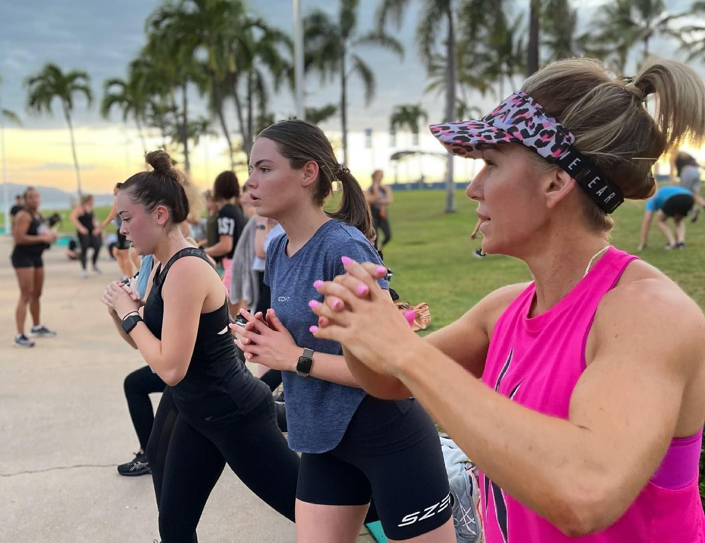 A Group Of Women Are Doing Stretching Exercises In A Park — Elev8ed Fitness In Currajong, QLD