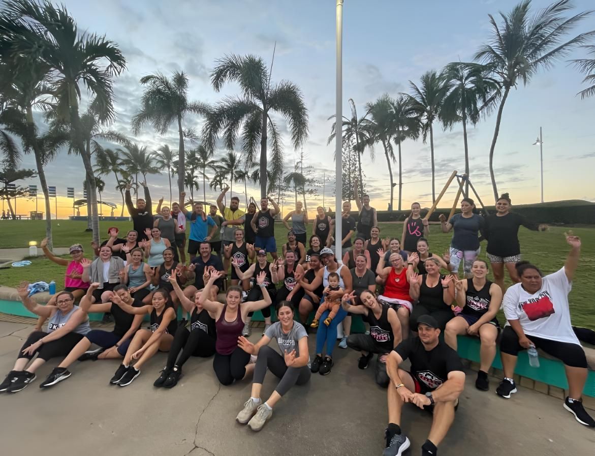 A Large Group Of People Are Posing For A Picture In Front Of Palm Trees — Elev8ed Fitness In Currajong, QLD