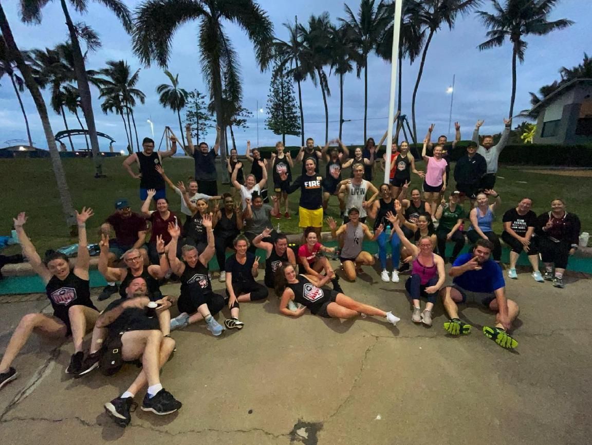 A Group Of People Are Posing For A Picture In Front Of Palm Trees — Elev8ed Fitness In Currajong, QLD