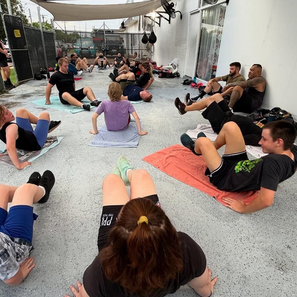 A Group Of People Are Doing Sit Ups On The Ground — Elev8ed Fitness In Currajong, QLD