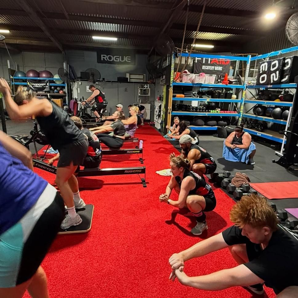 A Group Of People Are Working Out In A Gym With A Sign That Says Rogue — Elev8ed Fitness In Currajong, QLD