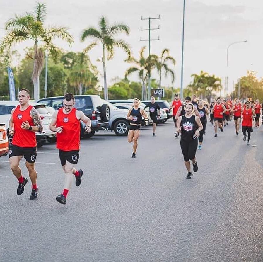 A Group Of People Are Running Down A Street — Elev8ed Fitness In Currajong, QLD