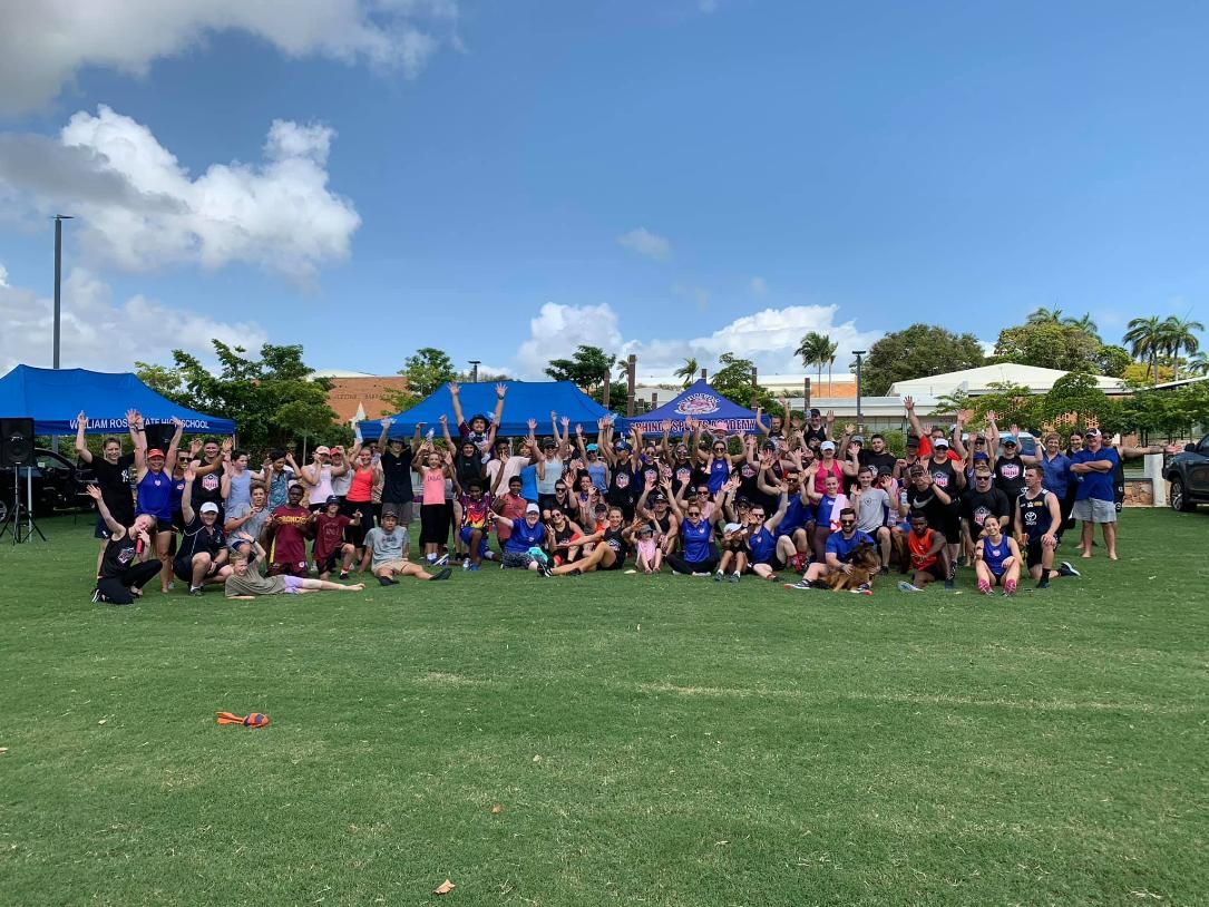 A Large Group Of People Are Posing For A Picture In A Field — Elev8ed Fitness In Currajong, QLD