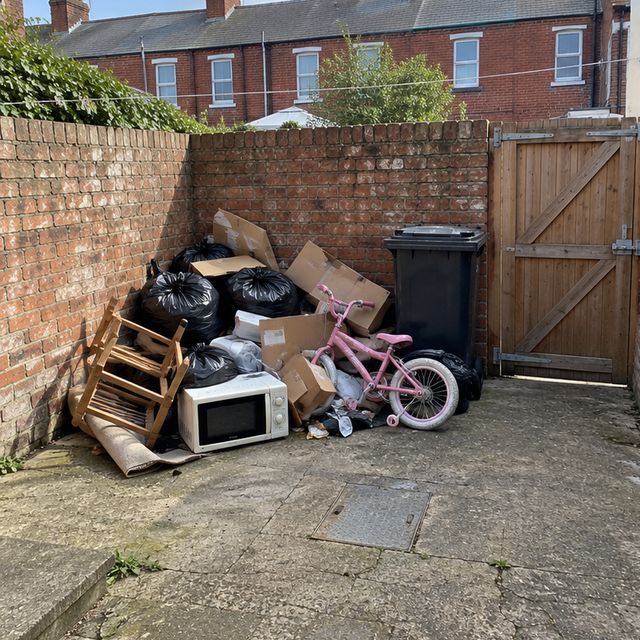 Before: household rubbish piled in a back yard