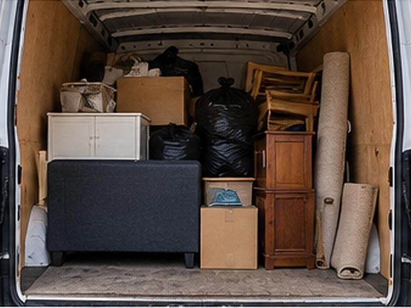 Van loaded with a cabinet, chairs, boxes and bags