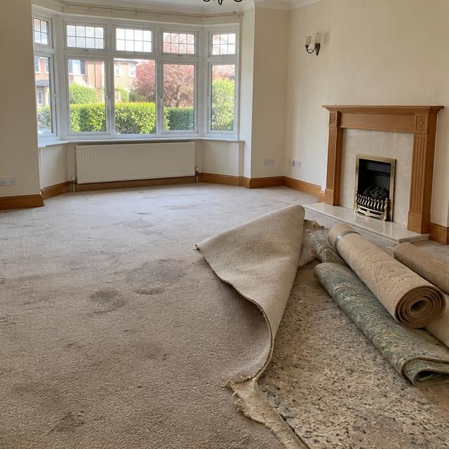 Before: old carpet and underlay pulled up in a living room