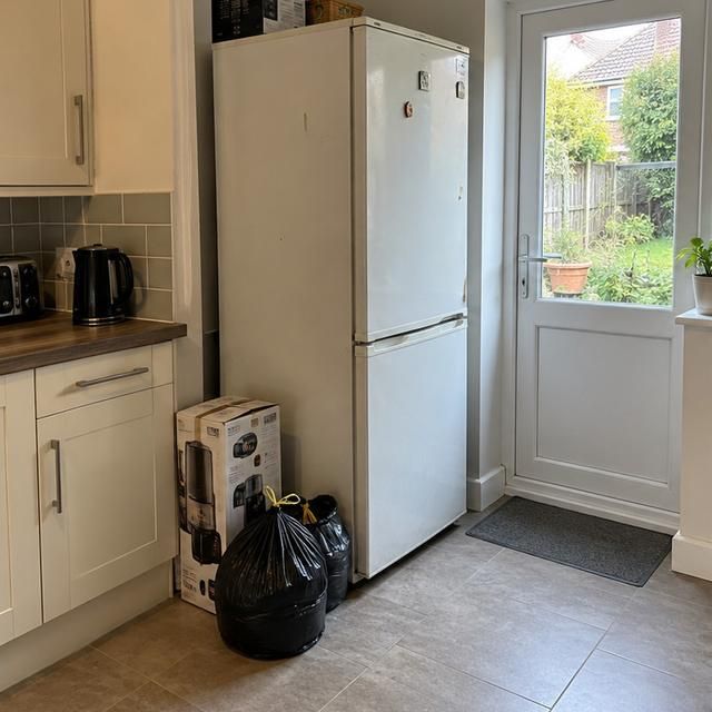 Before: an old fridge freezer in a kitchen