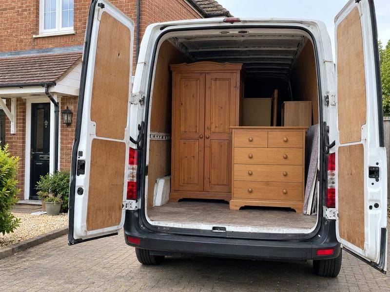 Wardrobe and chest of drawers loaded in the back of a van