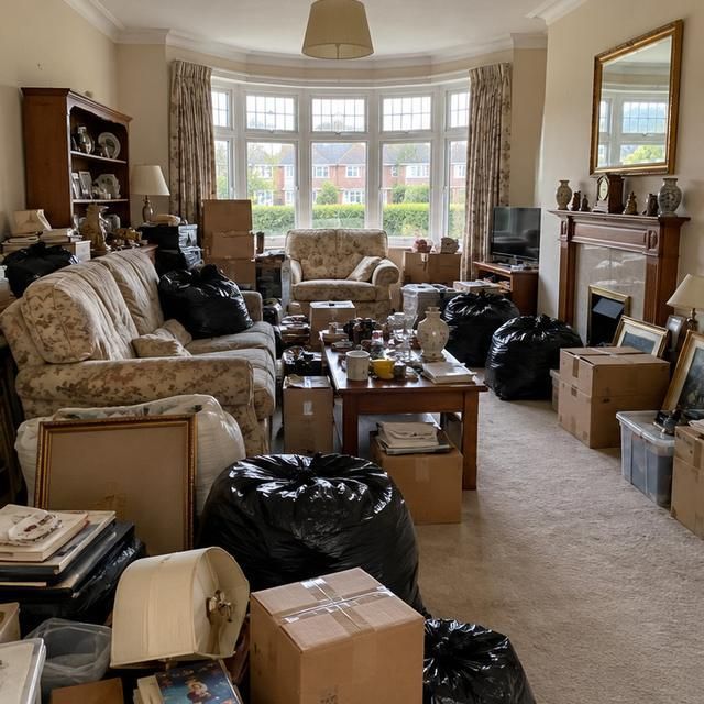 Before: a living room full of furniture, boxes and bags