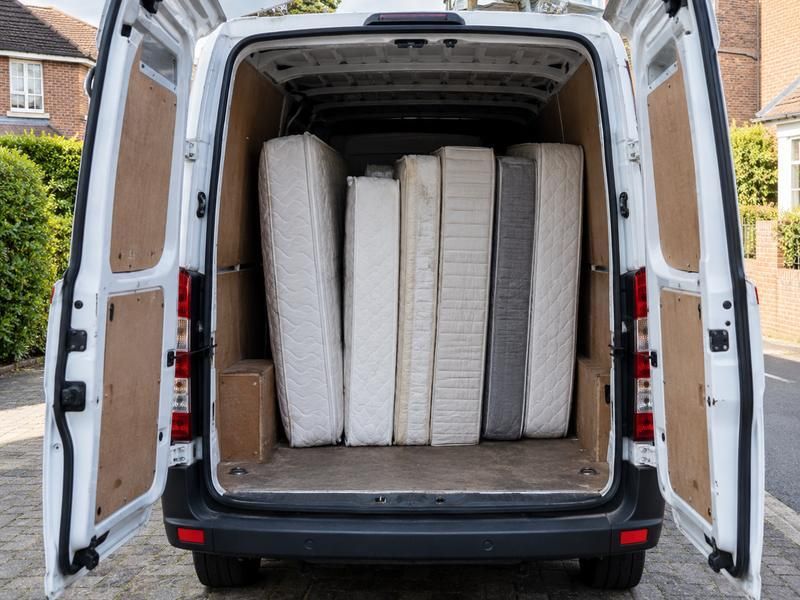 Mattresses stood upright in the back of a van