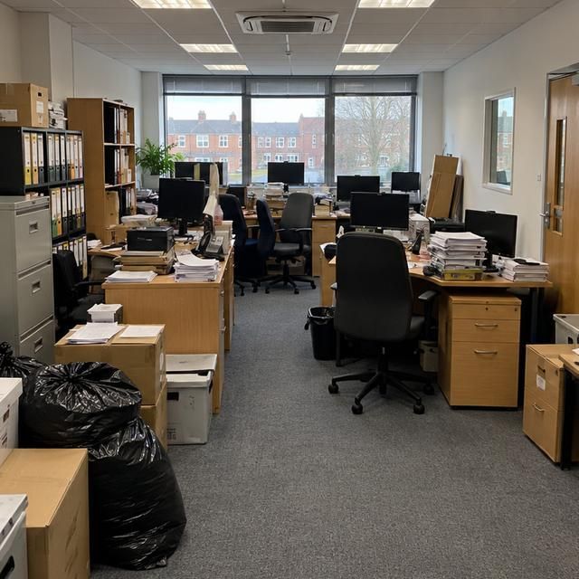Before: an office full of desks, chairs and boxes