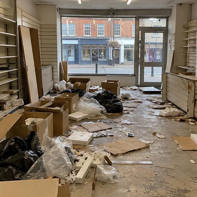 Before: an empty shop unit with debris and old fittings on the floor