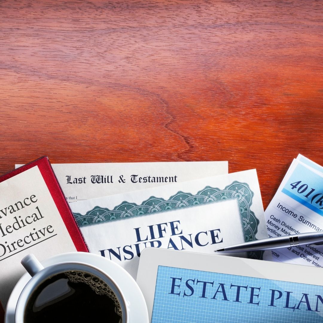 Documents related to estate planning and life insurance on a wooden desk.