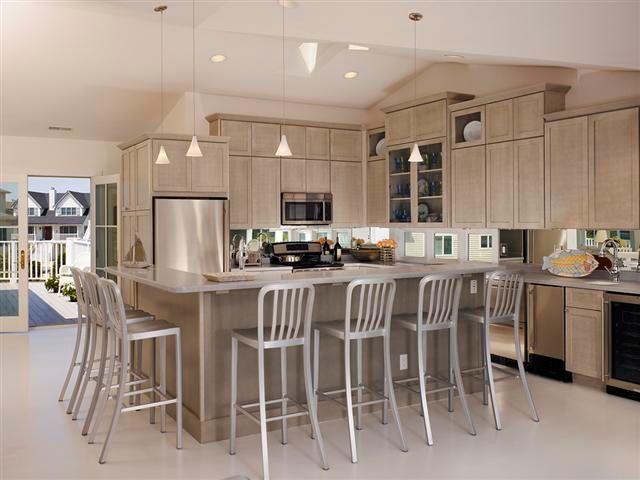 Modern kitchen with light wood cabinets, island seating, and stainless steel appliances